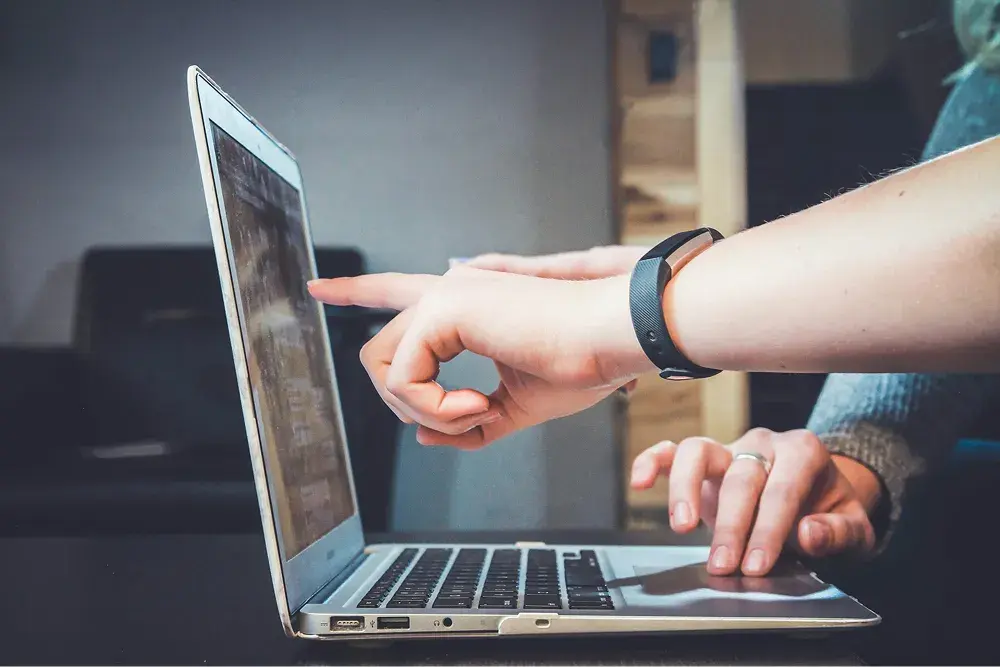 People looking at and pointing at a computer screen